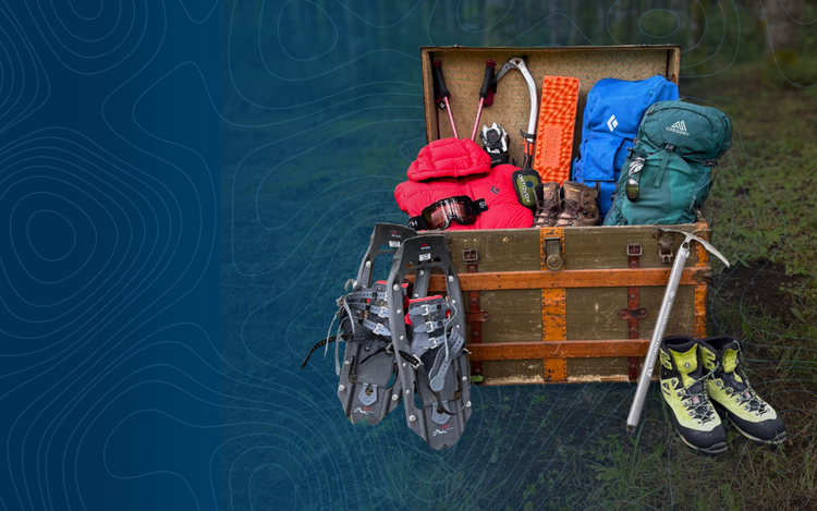 Vintage suitcase filled with hiking gear including backpacks, shoes, and tools on a natural background.